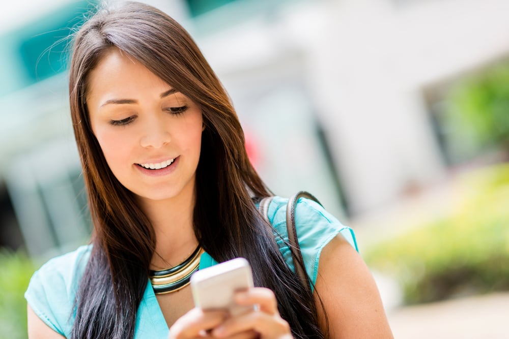 Beautiful casual woman texting on her cell phone