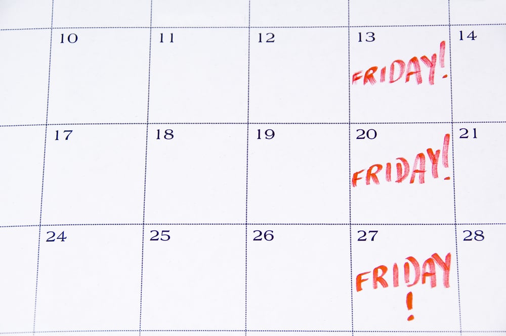 Close-up of white monthly calendar with FRIDAY! written in red