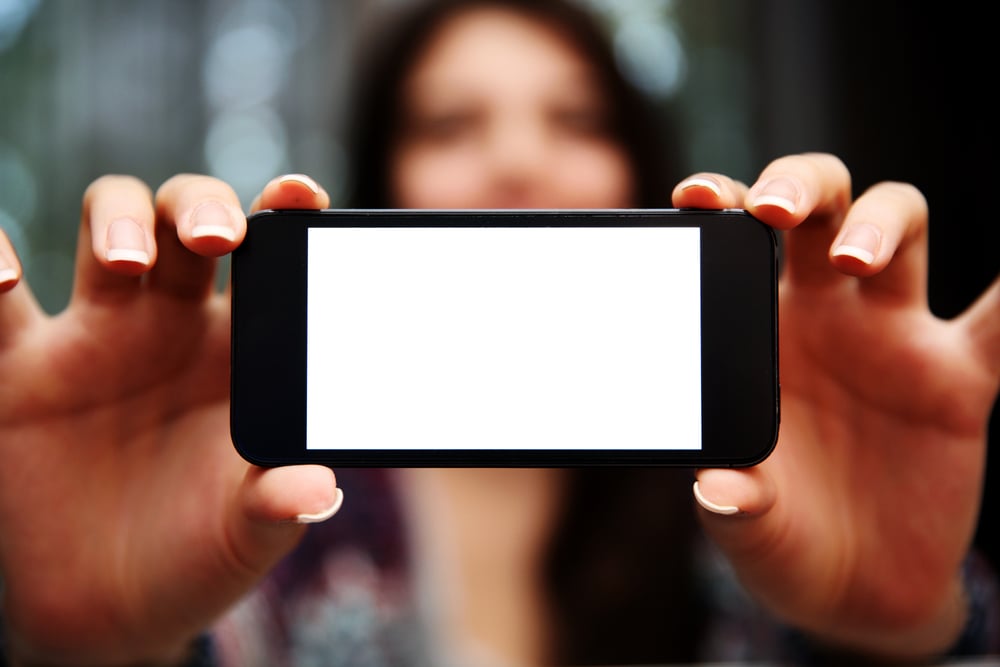 Closeup portrait of a woman showing smartphone screen