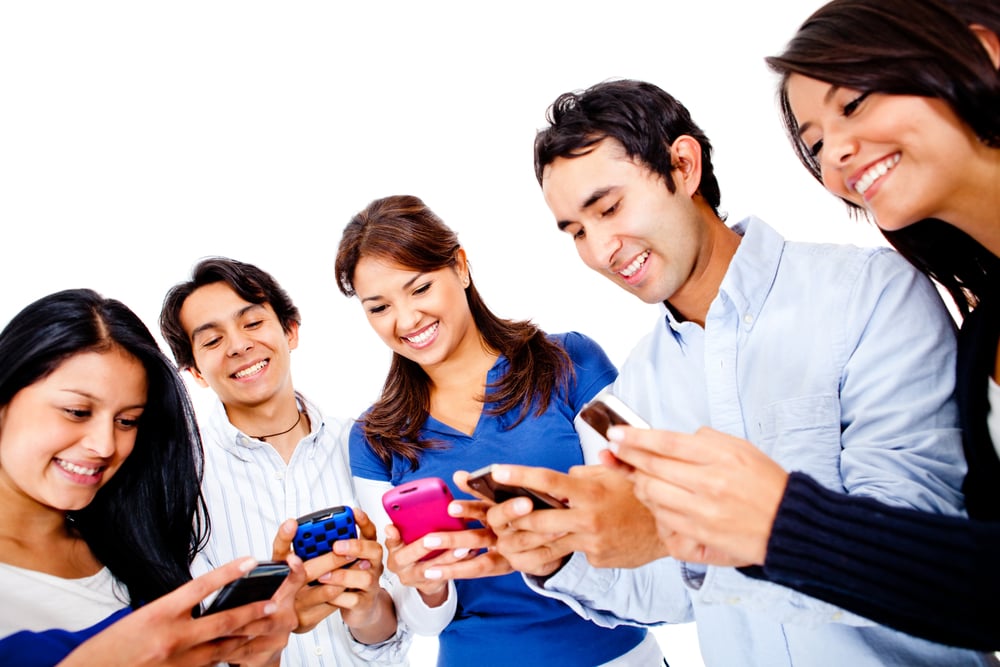 Group of young people texting on their cell phones - isolated over white