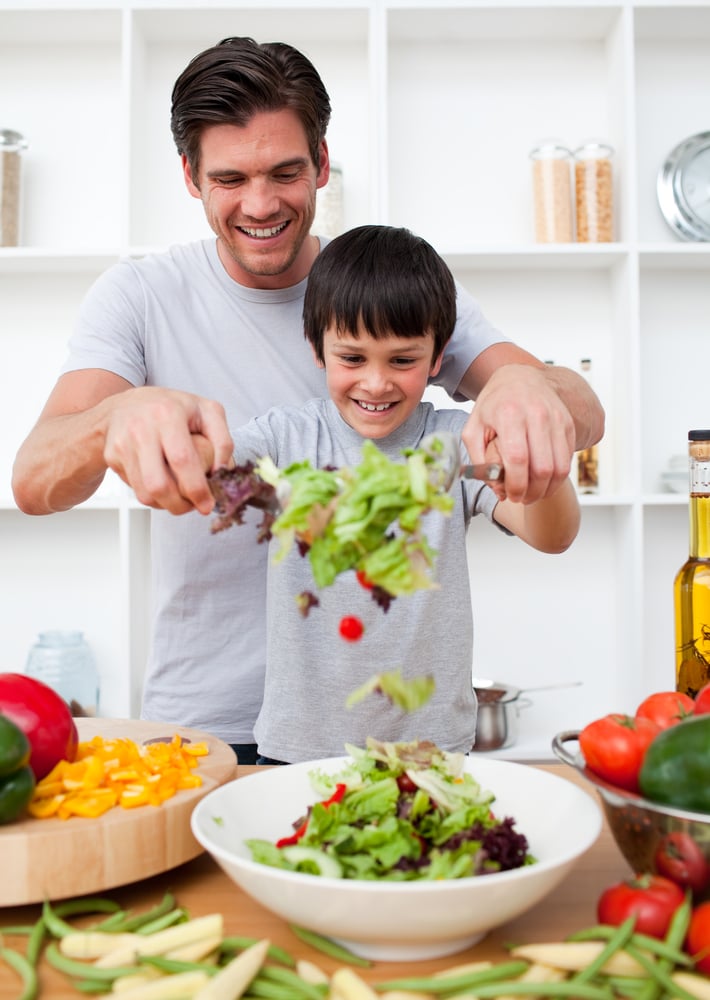 Little boy and his father cooking in the kitchen