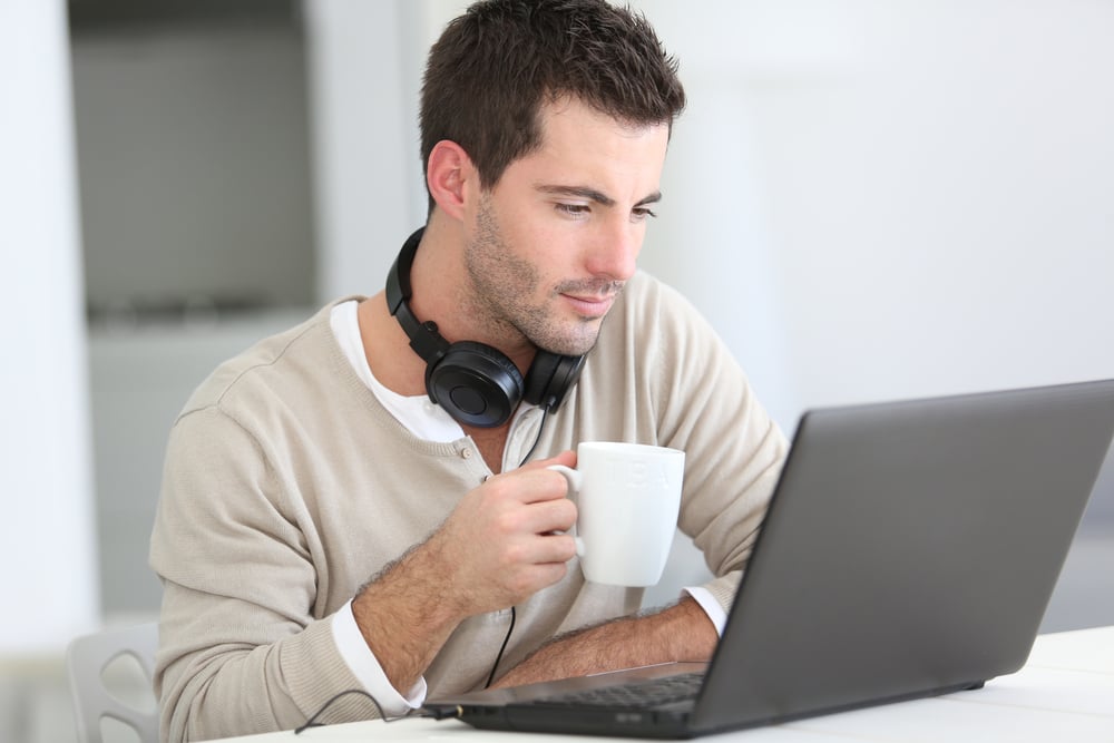 Man in front of laptop computer with headset