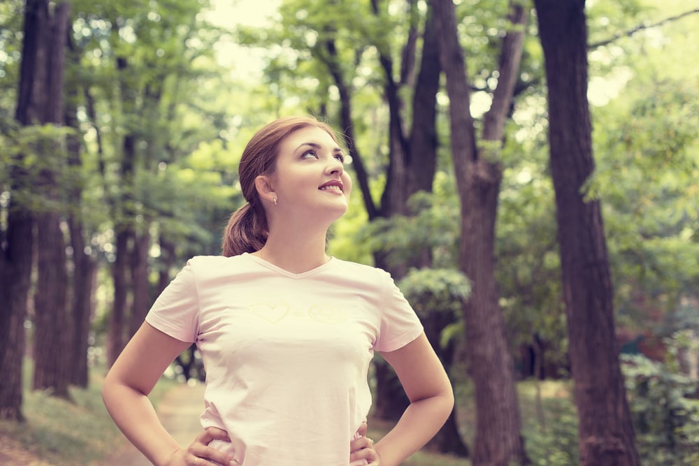 Portrait young attractive smiling fit woman resting after workout sport exercises outdoor looking up enjoying fresh air standing on background park trees. Healthy lifestyle well being wellness concept