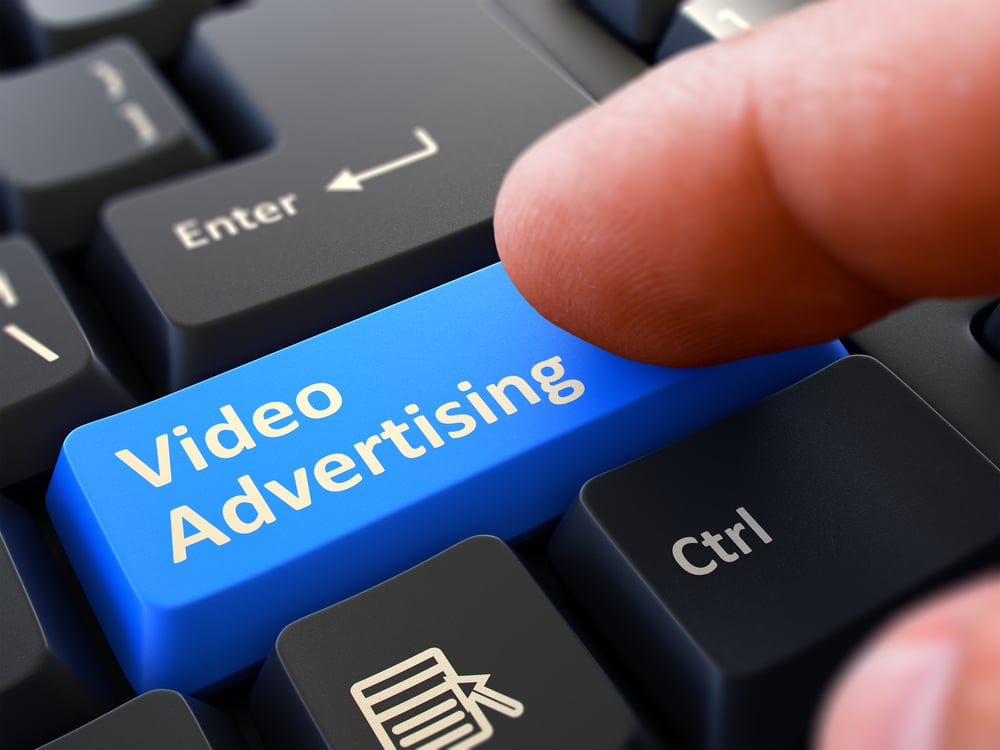 Video Advertising Button. Male Finger Clicks on Blue Button on Black Keyboard. Closeup View. Blurred Background.