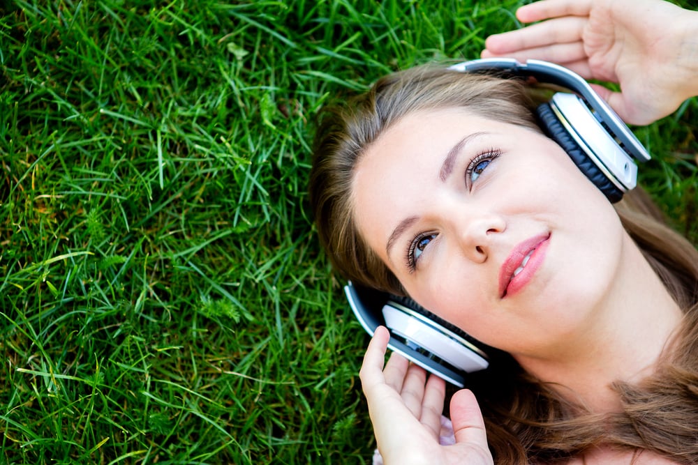 Woman listening to music with headphones at the park