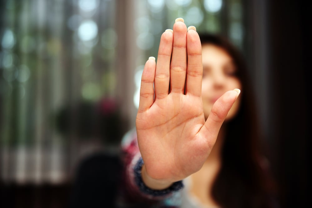 Woman with her hand extended signaling to stop (only her hand is in focus)-1
