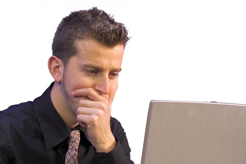 business man in front of a laptop very thoughtful